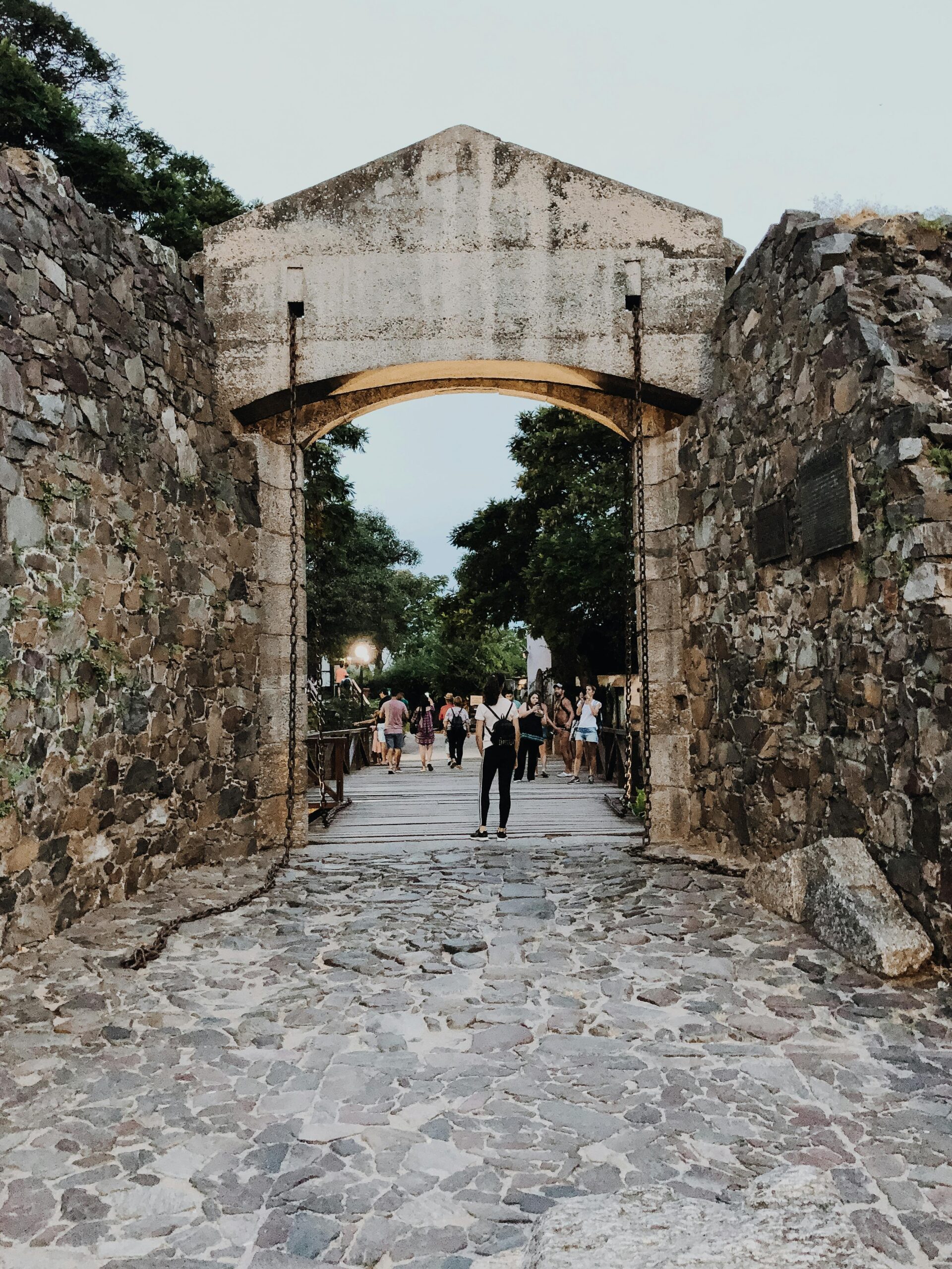 View through the historic gateway with stone walls and cobblestone street in Colonia del Sacramento, Uruguay.